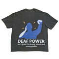 A dark gray graphic t-shirt laid flat on a light beige background. The back of the shirt features a blue silhouette of a person with a raised fist, yellow lightning bolts, and white text that reads 'DEAF POWER isn't quiet it's strong, visual and unstoppable'.