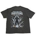 A dark gray graphic t-shirt laid flat on a light gray background, showing the back side with a white and black design that reads 'POWER COMES FROM SURVIVING THE SILENCE.'.