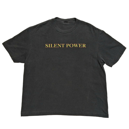 A dark charcoal gray short-sleeve t-shirt with the words 'SILENT POWER' printed in gold serif lettering across the chest, laid flat against a light gray background.